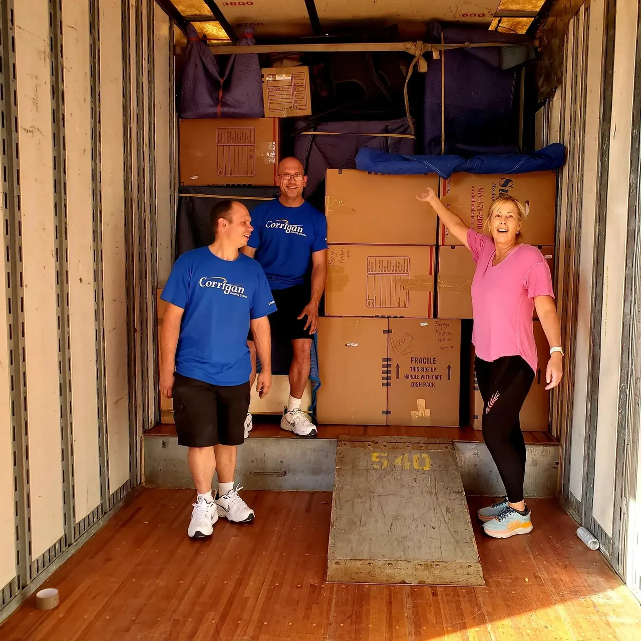People standing in a packed moving truck.