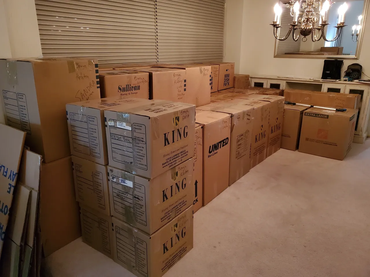 Room filled with stacked moving boxes.