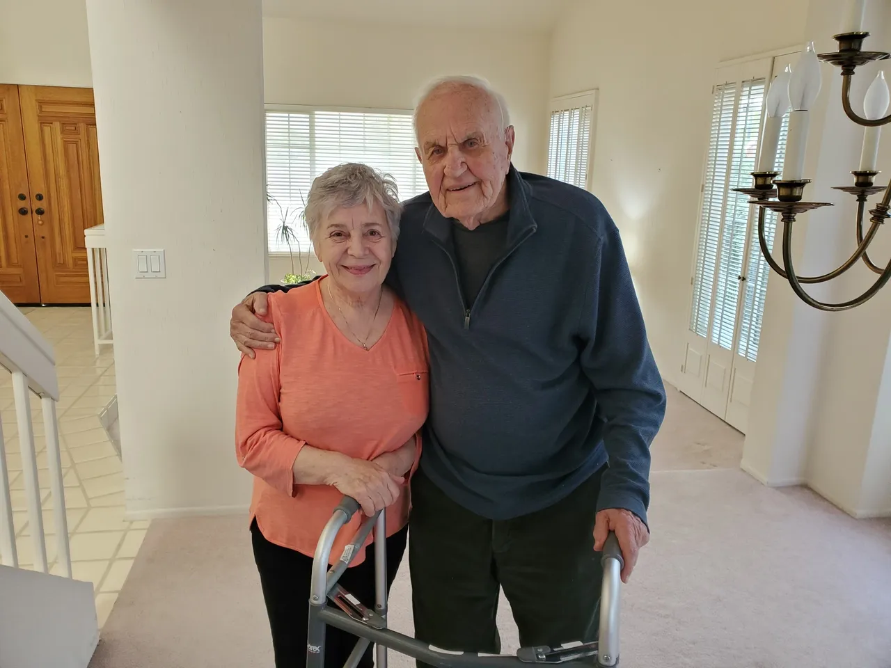 Elderly couple smiling in their home.